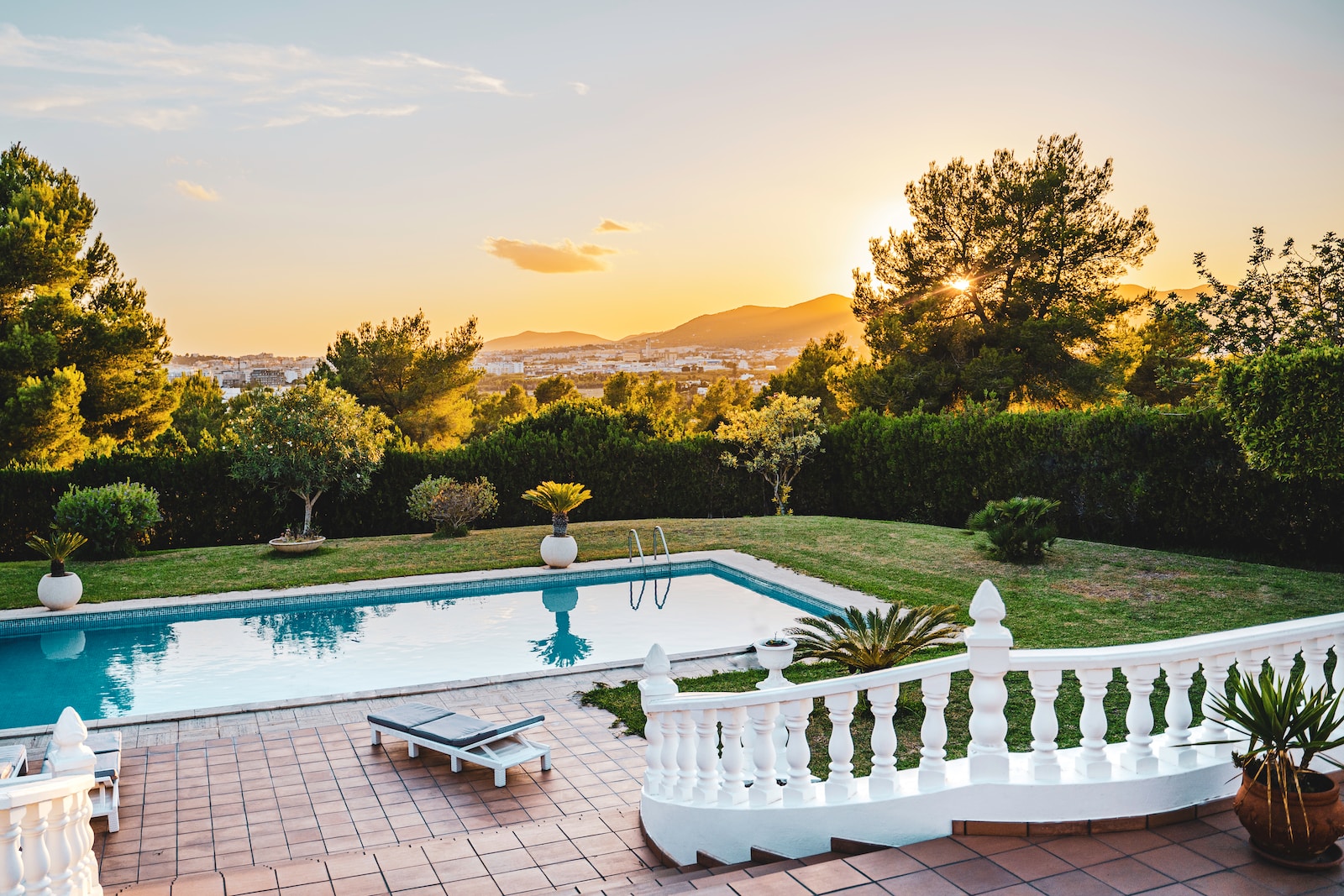 white outdoor pool near green trees during renotravaux sunset